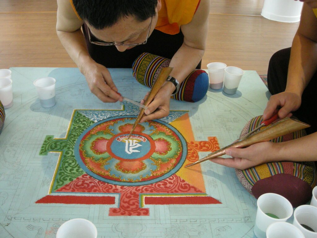 Monks making a detailed Tibetan sand mandala